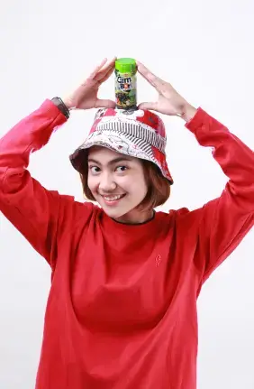 smiling woman dressed all in red holding Indonesian Mamasuka snack products wanita tersenyum berpakaian serba merah memegang produk camilan mamasuka indonesia